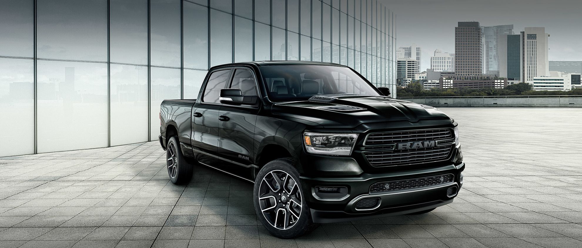 2020-ram-1500-dt-hero-desktop-black-parked-city-skyline_fccc83d659ac37ec81e477ddfda1e5b3-2496x1066
